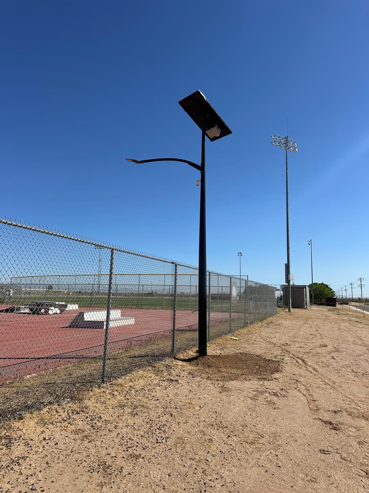 Completed All Seasons pole alongside the chainlink fence at the Adelanto skatepark perimeter