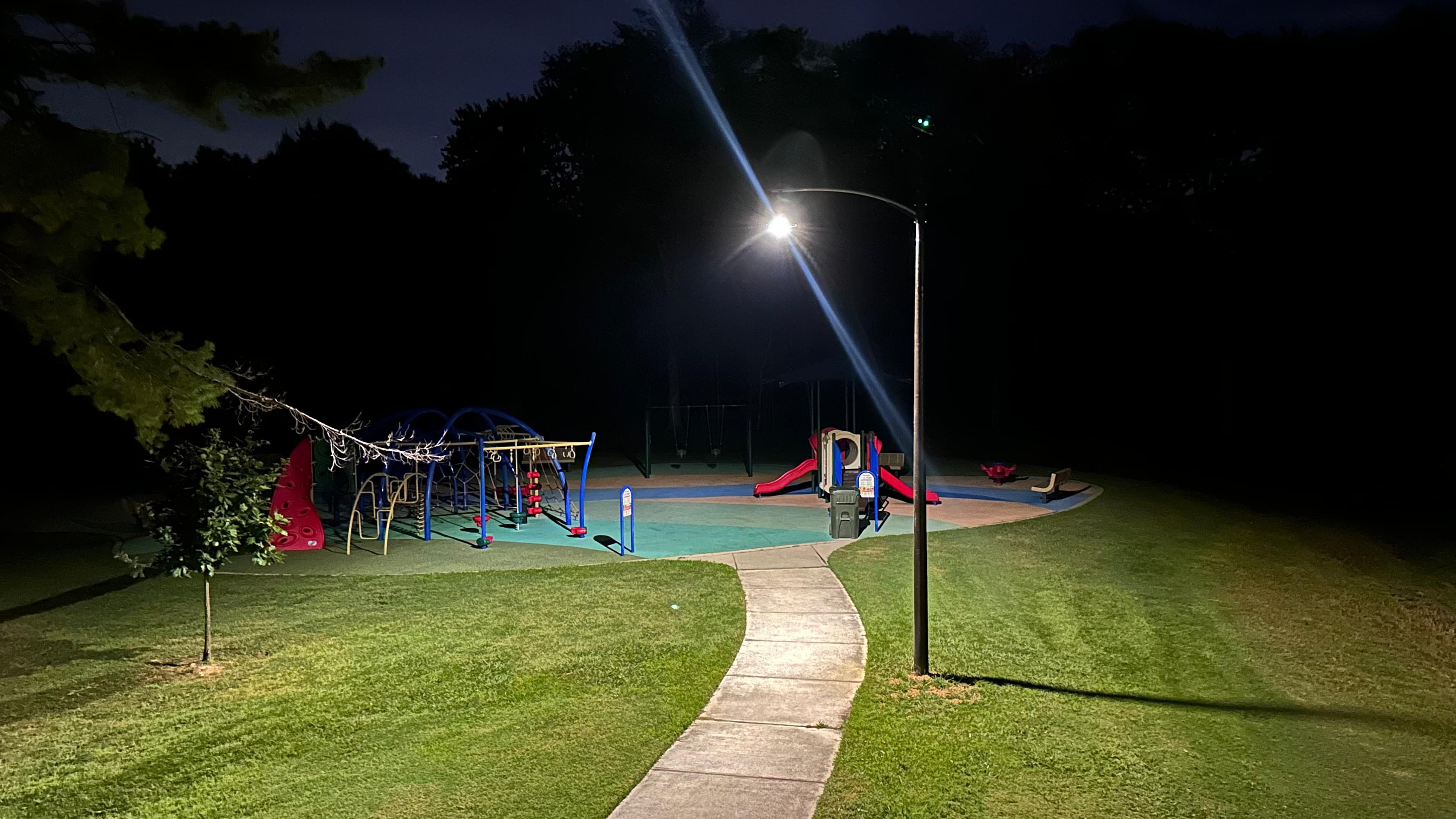 All Seasons pole lighting the playground equipment at Riverview Park at night