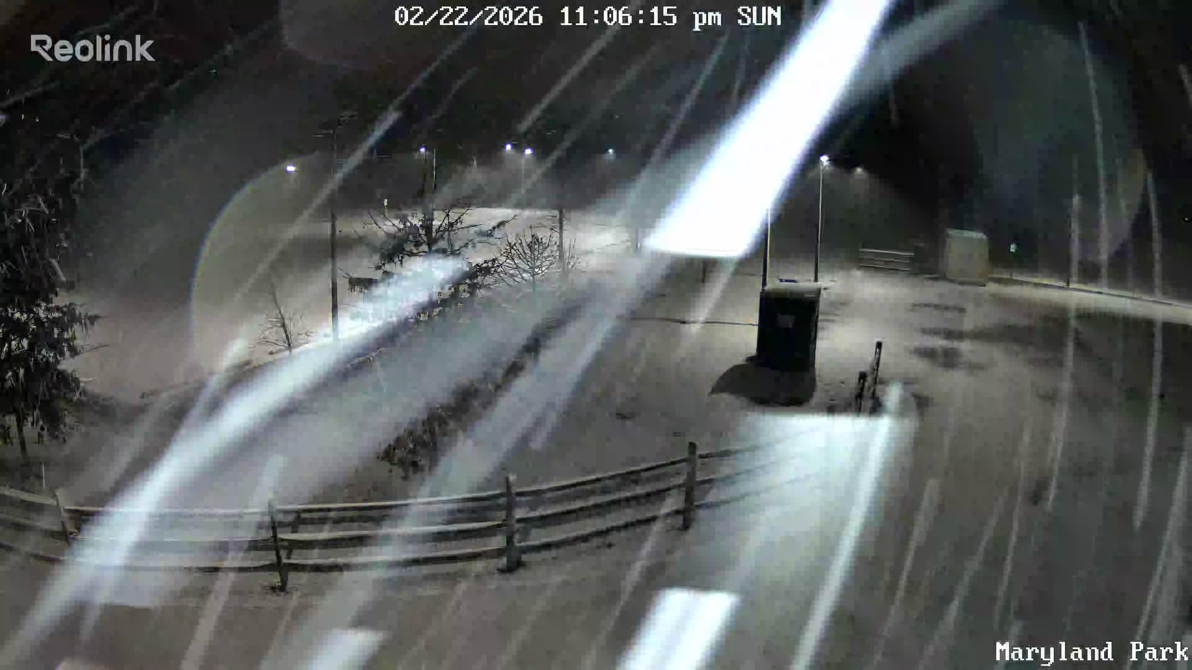 Reolink camera screenshot during a heavy snowstorm at Riverview Park, snow streaking across the frame, All Seasons poles still illuminated