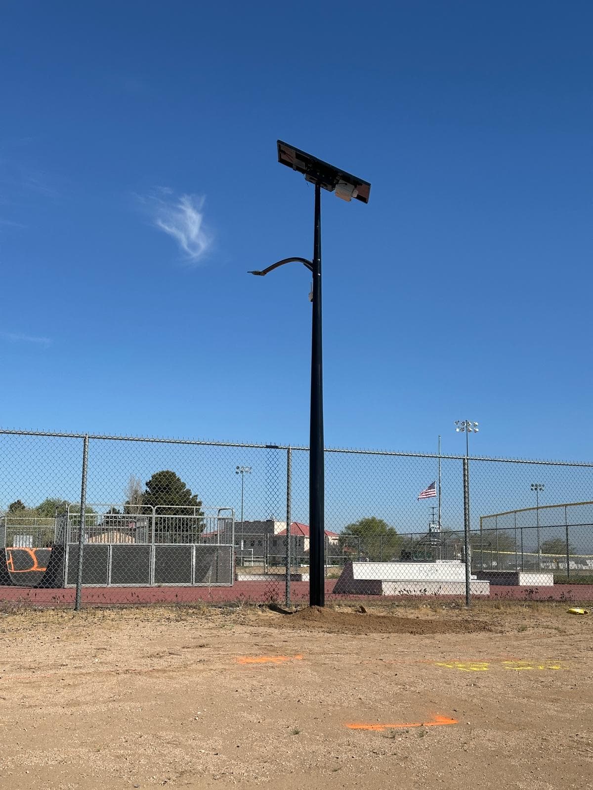 Completed All Seasons pole at the Adelanto sports complex, American flag visible at the baseball field beyond